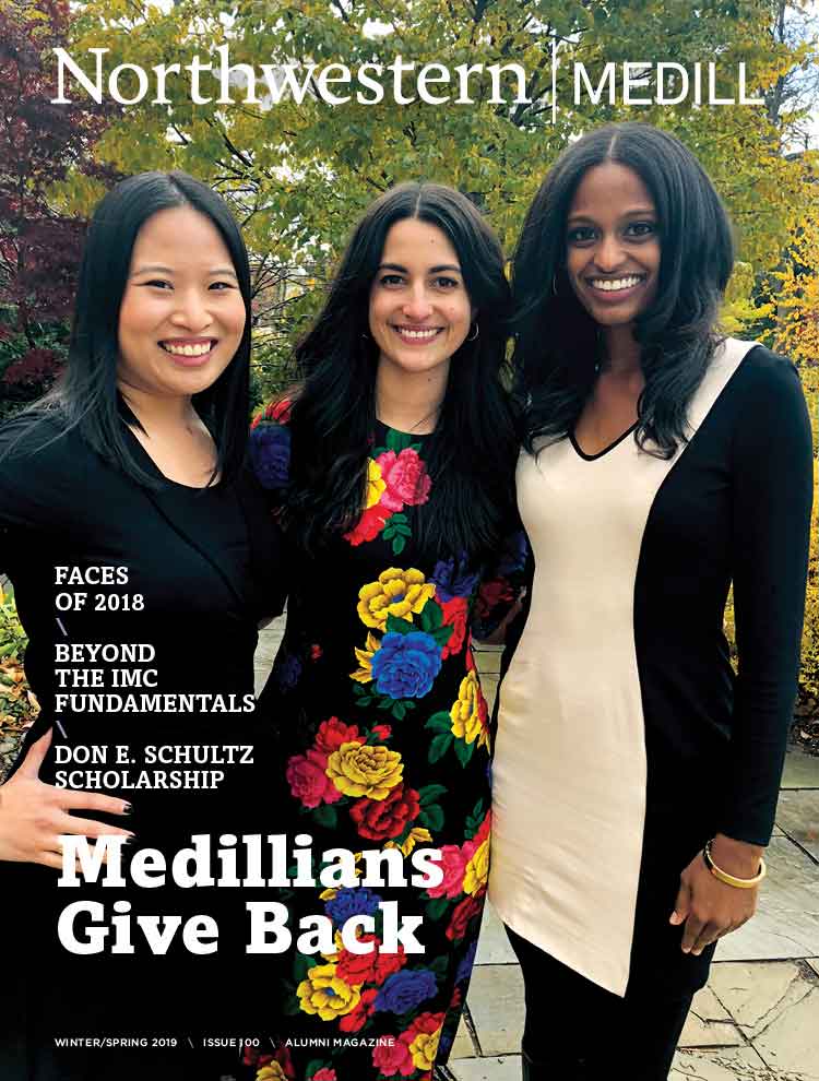 Three alumnae pose for a photo outside on campus