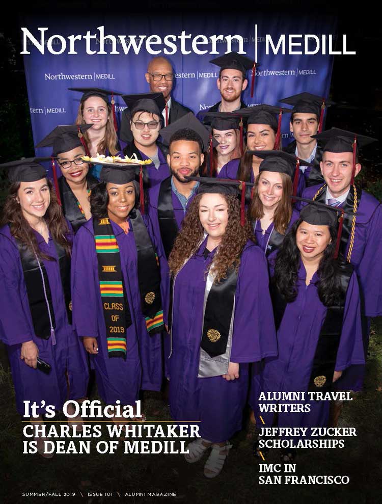 Medill Dean Charles Whitaker poses for a photo with graduates in caps and gowns