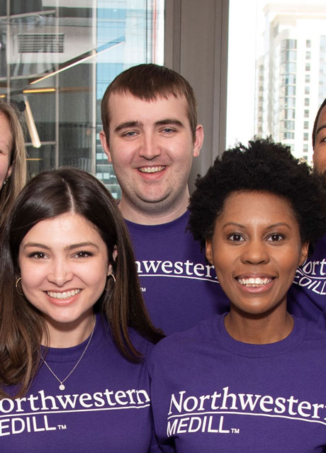 A group of students in purple Northwestern Medill shirts.