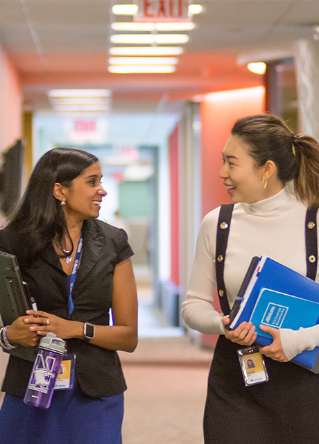 Two IMC students walking down a hallway