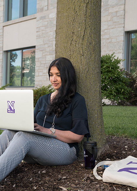 Student with laptop taking an online course outside