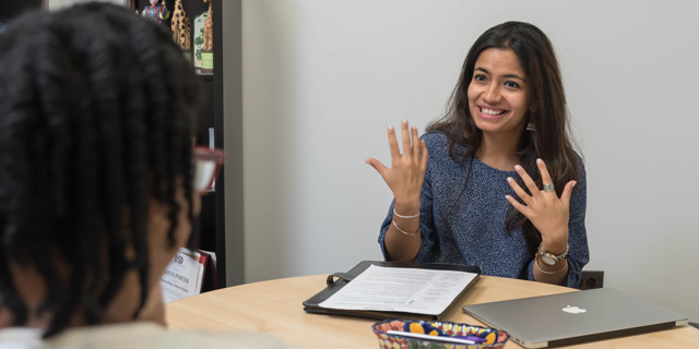 A student sitting at a table with a career coach.