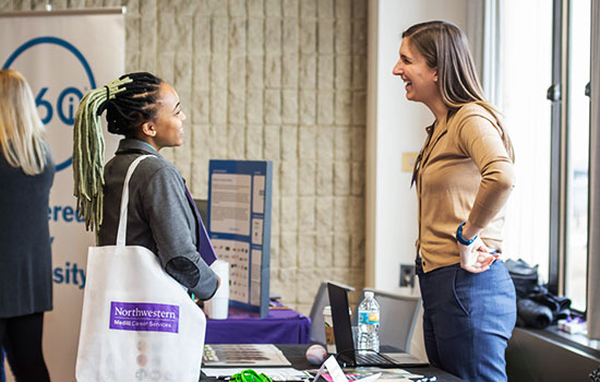 A student talking with a worker at a career fair.