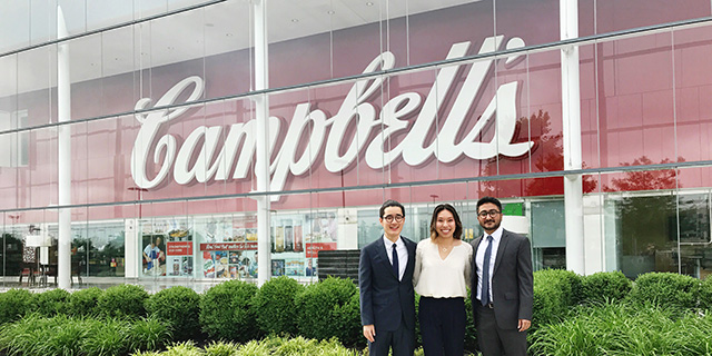 Students in front of Campbell's Soup sign.