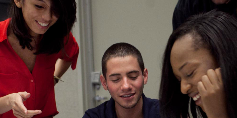 Three students work together on a project