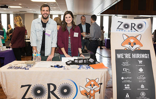 A Zoro branded table staffed by two Zoro workers at a career fair.