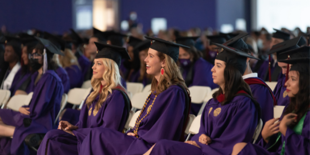 IMC graduates celebrating with a faculty member.