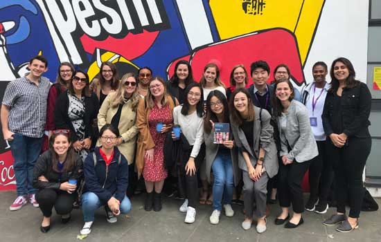 A large group of students pose for a photo at the Museum of Brands in London