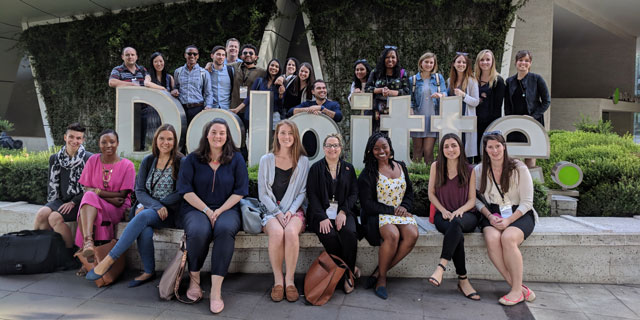 Medill IMC students pose for a photo by the Deloitte sign in Santiago, Chile