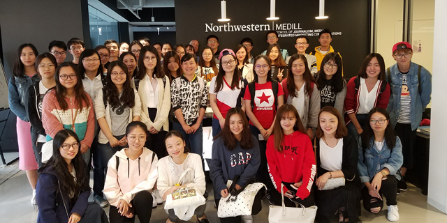 A group of students poses for a photo at Medill's downtown campus