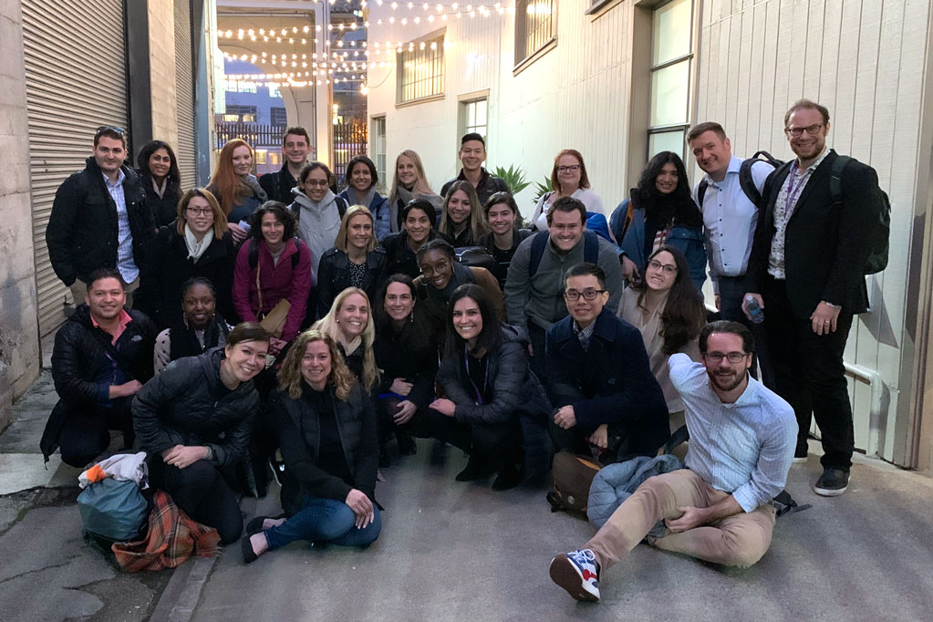 Students pose for a photo at a site visit during an IMC course