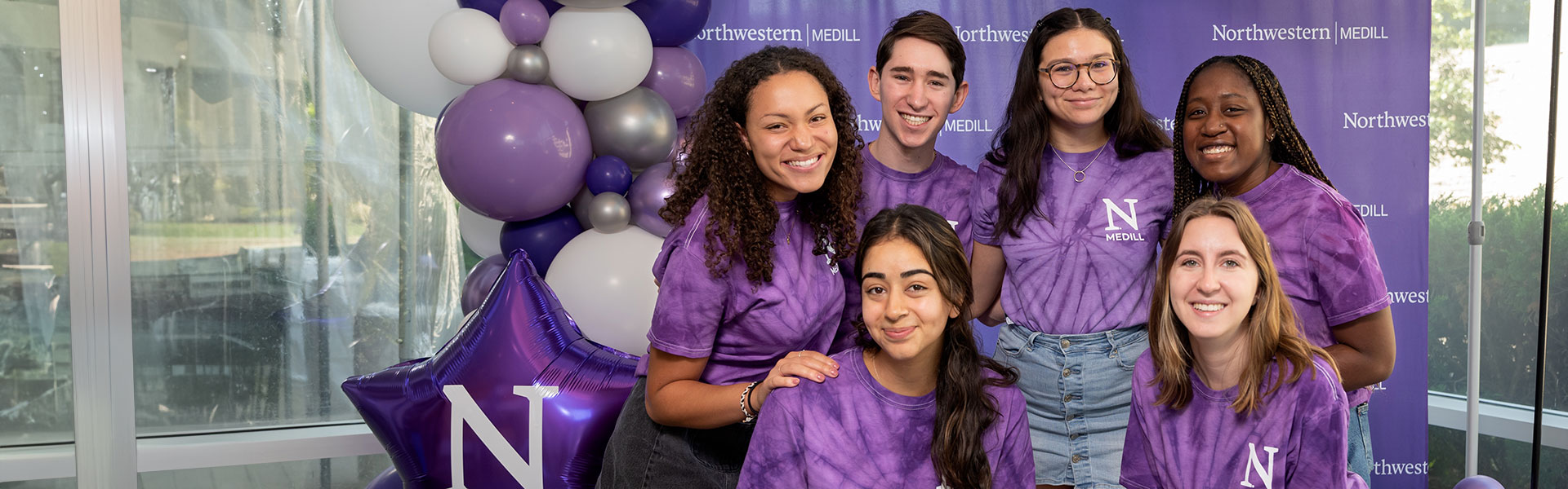 A group of students in purple tie-dye shirts.