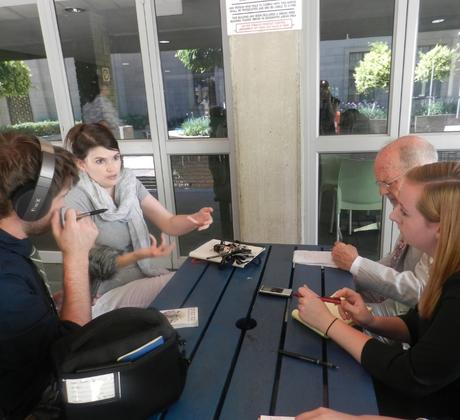 A student conducting an interview while recording and wearing headphones.