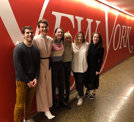 Students pose in front of a sign that says New York.