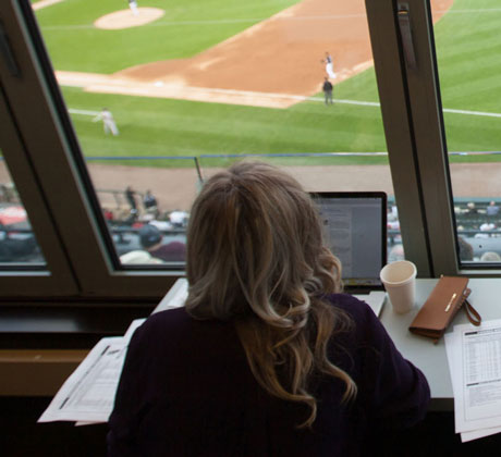 Student reports on a baseball game while overlooking the field.