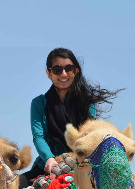 A woman riding a camel.