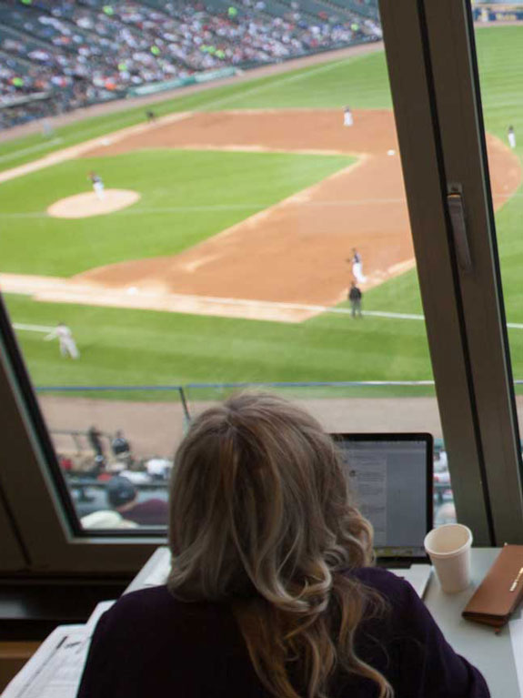 Students in the press box at a baseball game.