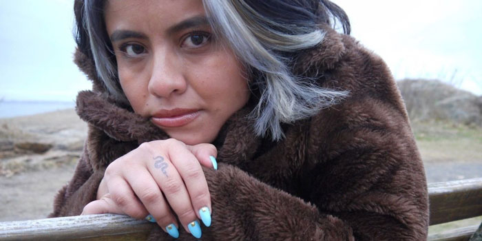 Woman sitting on park bench looking at camera.