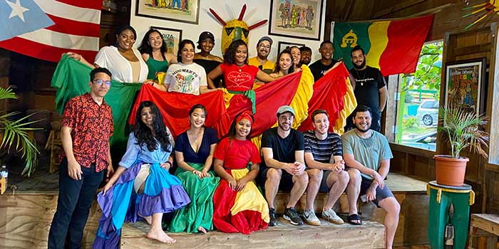 Students posing for a photo with a woman wearing a colorful dress.