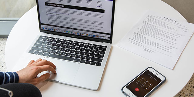 Close up photo of hands typing on a computer.