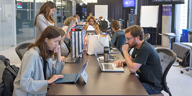 Students work inside of the Medill Chicago Newsroom.