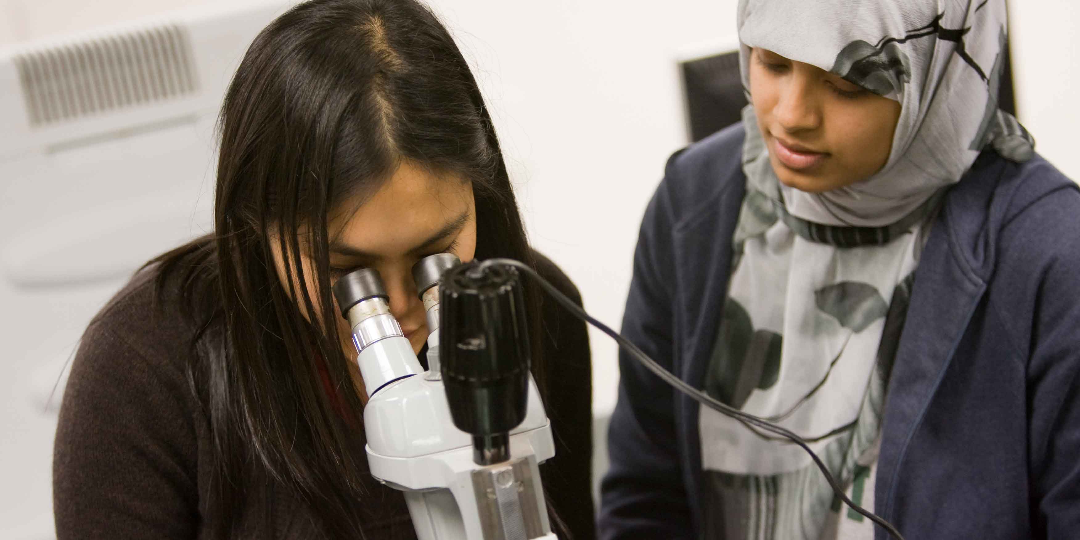 Two students using a microscope.