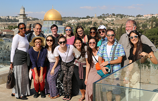 A group of students pose in front of a mosque in Israel.