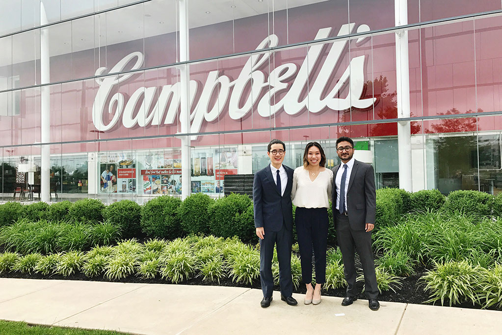 Students standing in front of Campbell's soup sign.