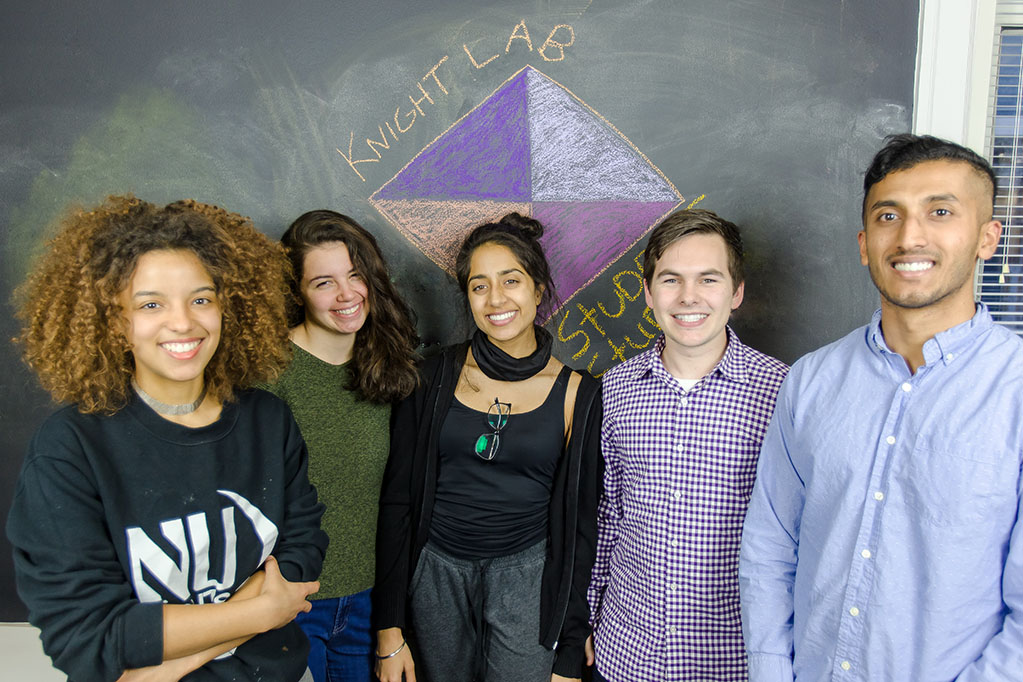 Students smile in front of a sign that says "Knight Lab."