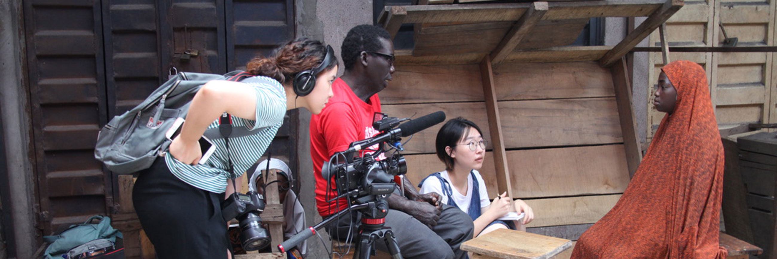 Students interview someone on camera for a documentary.