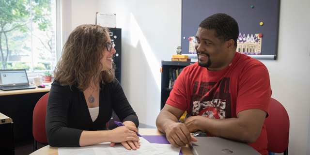 A career services professional works with a student on career preparation.
