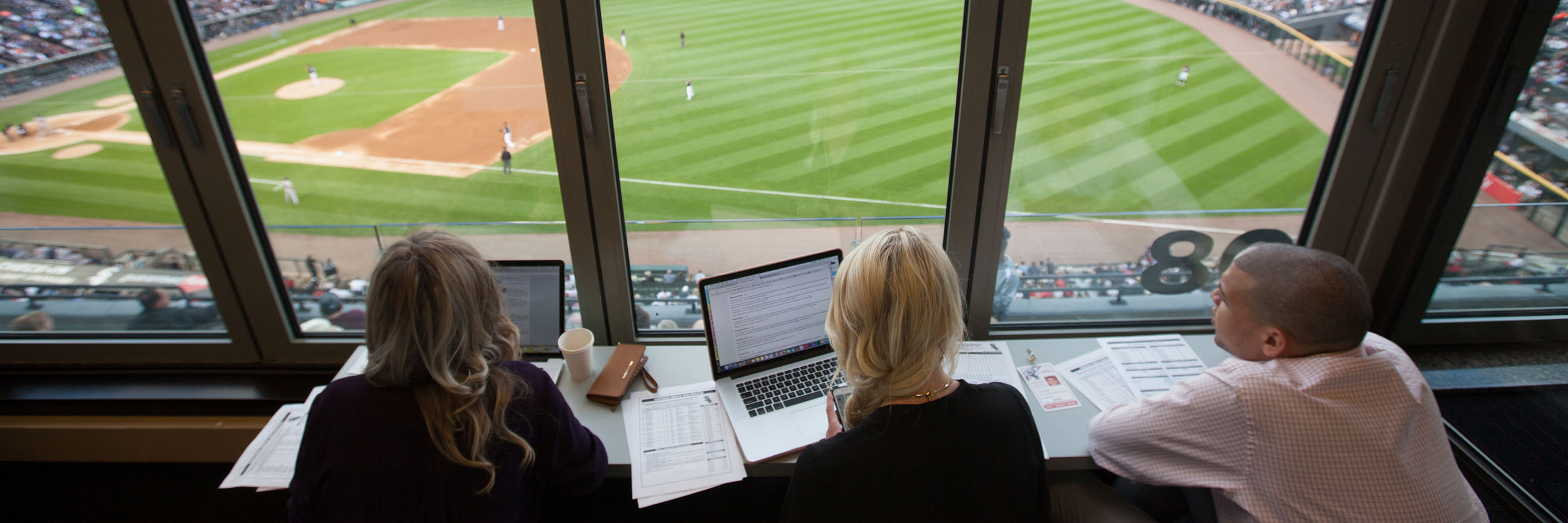 Students in the press box at a baseball game.