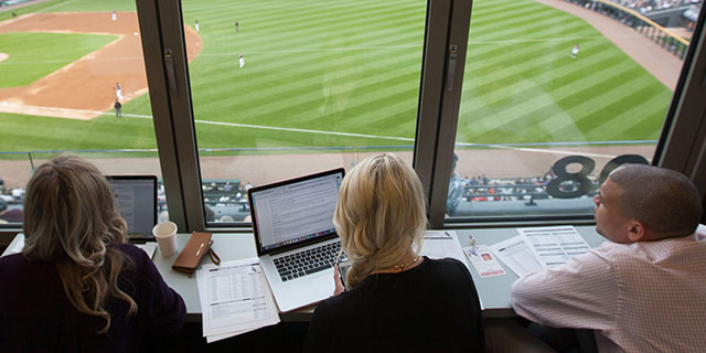 Students in the press box at a baseball game.