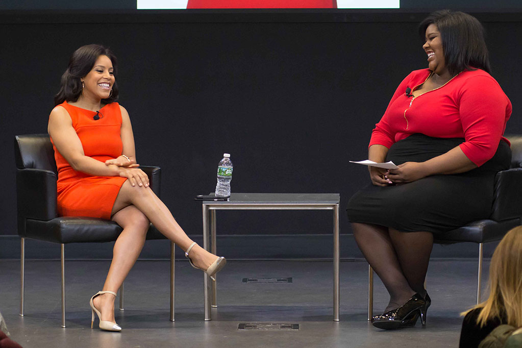 Sheinelle Jones talking with a student on stage during a panel discussion.