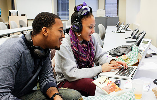 Two students working on a computer.