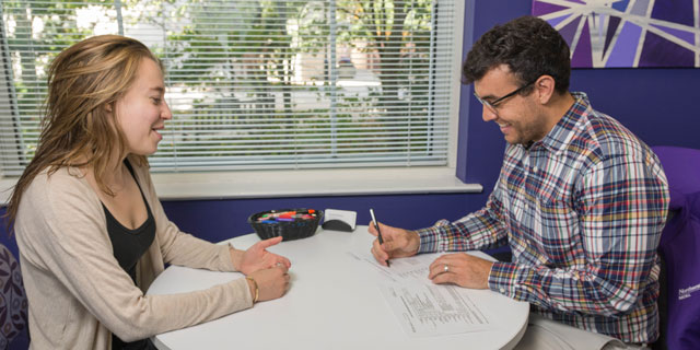 A staff member in the Medill Office of Student Life advises a Medill student