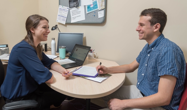 Student working with a career coach on interviewing in an office.