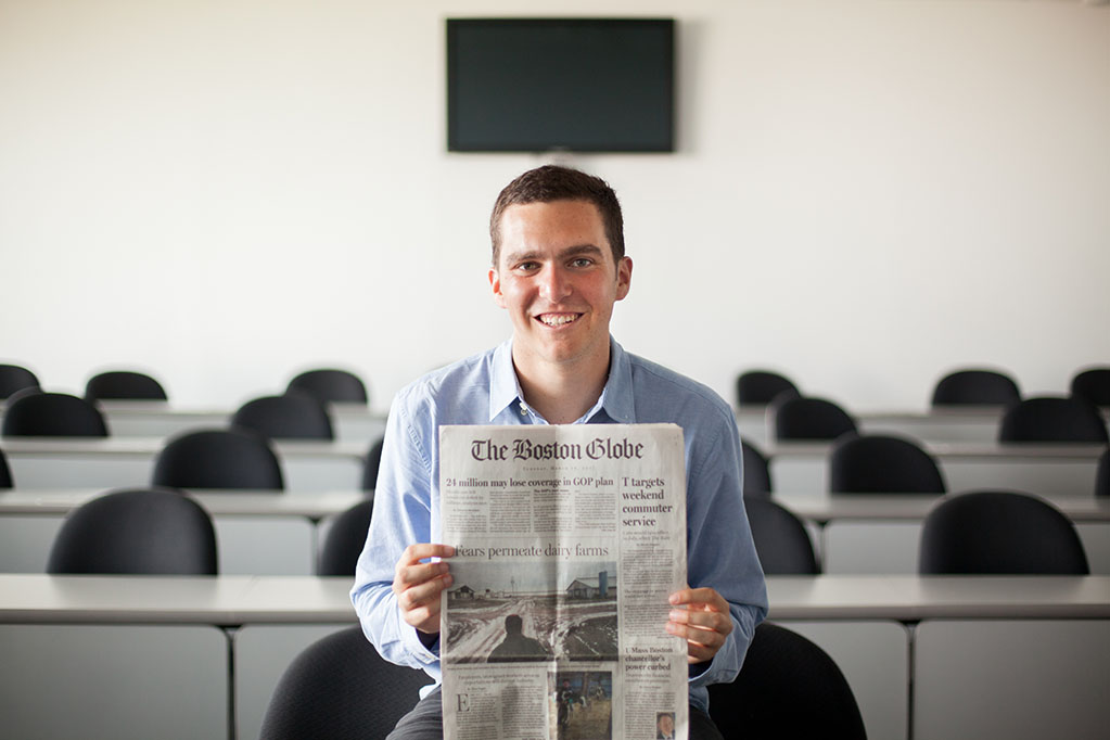 Tyler Pager holding up the front page of The Boston Globe