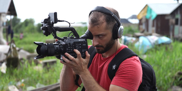 A student holds a video camera to record footage for a documentary.