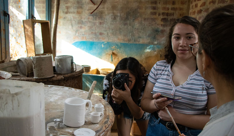 Medill student takes photos of ceramics inside of a Cuban art shop.