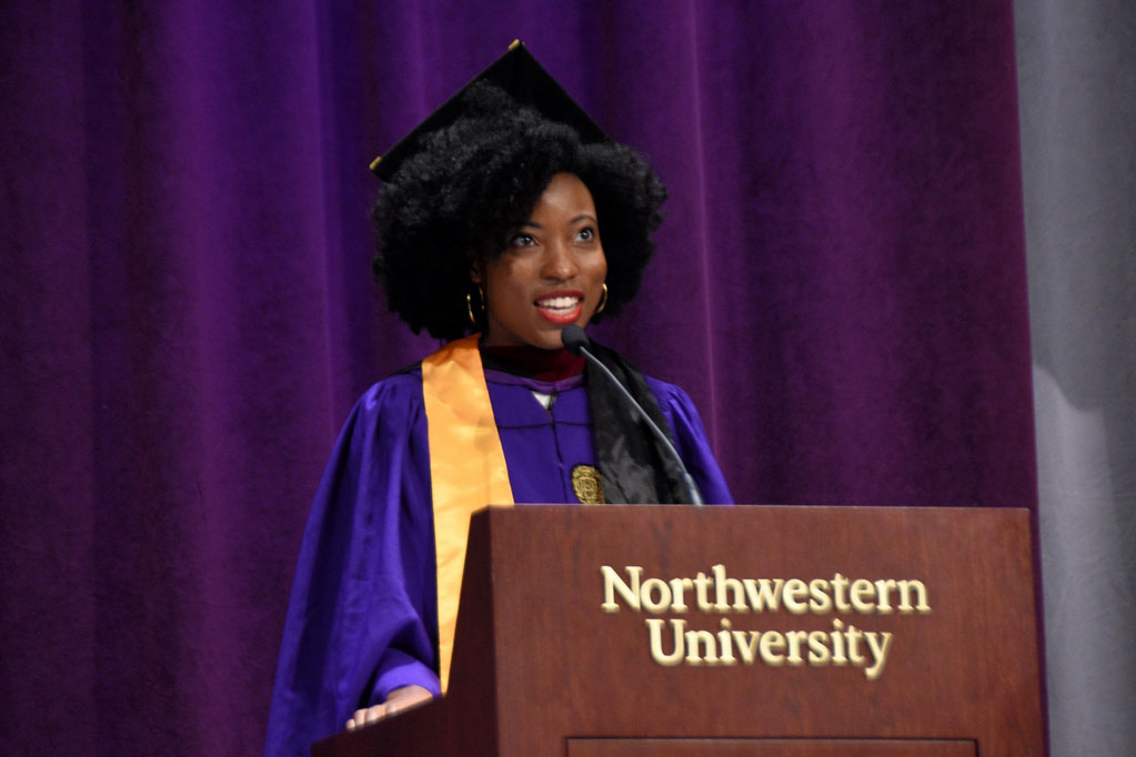 A student speaks at a lectern during a convocation ceremony