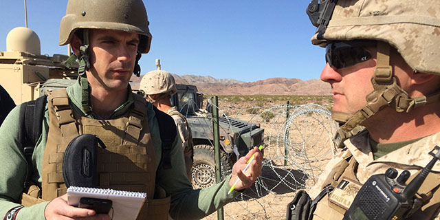 Student wearing helmet and speaking to the army.