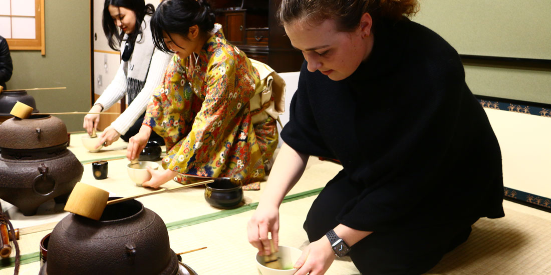Students engage in a Japanese cultural practice. 