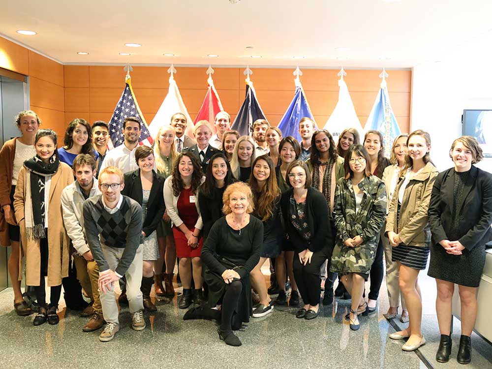 A group of approximately 35 people pose for a photo at the Defense Health Headquarters