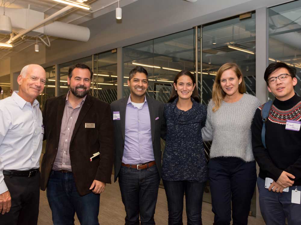 A group of six people pose for a photo at Medill Chicago