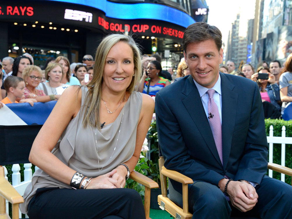 Mike and Stacy Greenberg sit in chairs and smile at the camera