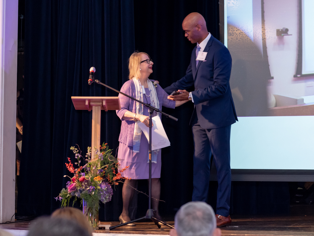 Mary Dedinsky accepting Hall of Achievement award from Dean Charles Whitaker.