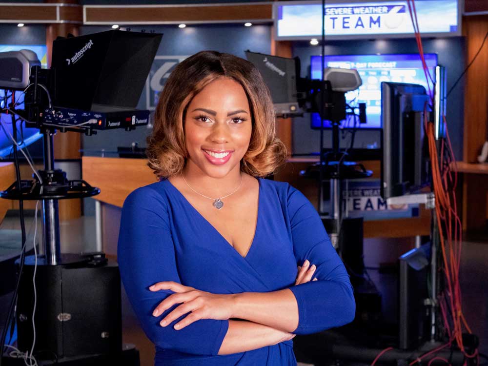 Alexis Wainwright poses for a photo in front of video equipment