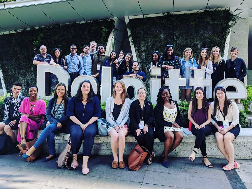 Students pose for a photo with the Deloitte sign in Santiago