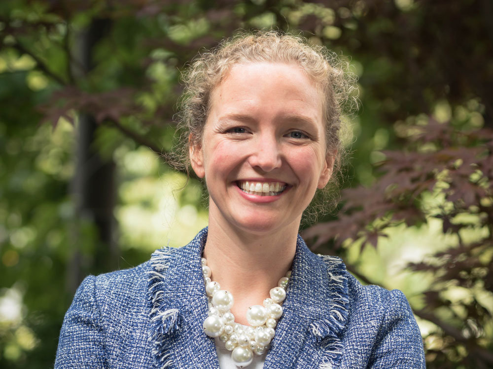 Sara Nelson poses for a headshot photo by some trees on the Evanston campus